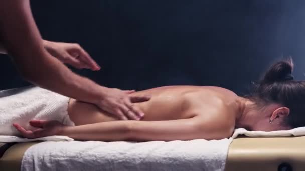 Massage session i den rökiga studion - terapeut massera unga kvinnor tillbaka — Stockvideo