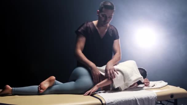 Massage session i studion - massagist trycka på damernas kropp över handduken — Stockvideo