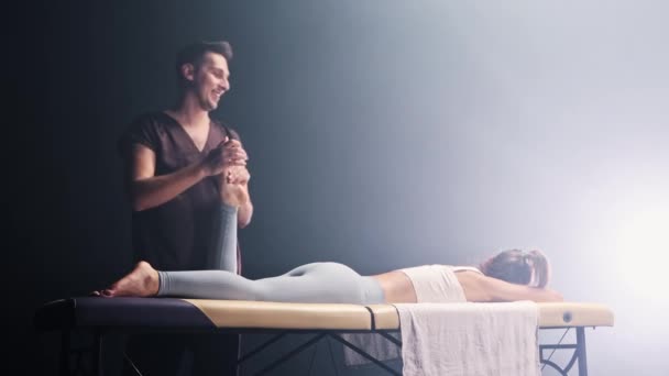 Massage sessie in de rokerige studio - de therapeut masseren vrouwen voet — Stockvideo