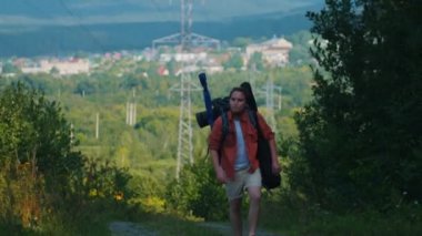 Ormanda yürüyen büyük sırt çantalı sakallı bir gezgin.