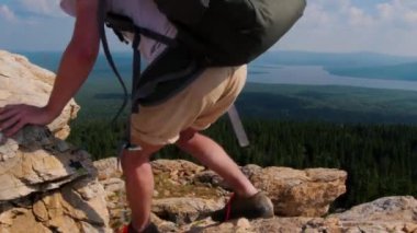 Genç bir kadın ve bir adam dağdan aşağı iniyor.