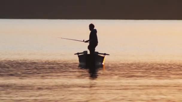 Jongeman op de visserij - houden van de hengel en staan op de boot — Stockvideo