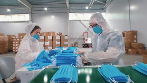 Industrial production of protective medical masks on thr factory - workers packing the masks together — Stock Video