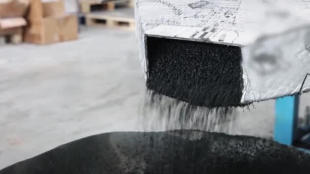 Férfi kezében műanyag fekete szürke granulált morzsa öntés a zsákba — Stock videók
