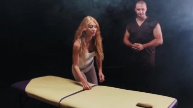 Genç bir kadın kanepede yatıyor ve bir terapist ona masaj yapmak üzere.