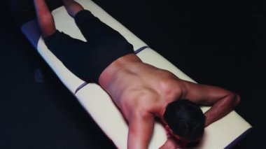 Stüdyoda kayropraktik terapi. Erkek bir terapist, erkek müşterisinin ayağına masaj yapıyor.