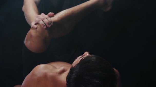 Хиропрактика в студии - мужчина-терапевт, давящий на ногу своего клиента по направлению к его телу — стоковое видео