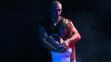 Karanlık stüdyoda kiropraktik terapi. Kadın müşterisiyle çalışan bir adam. Kadın koltukta otururken omuz omuza.