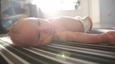 Sırtüstü uzanmış küçük mutlu bir bebek.