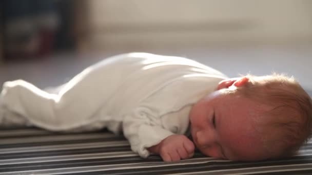 Ett litet nyfött barn som ligger på golvet — Stockvideo