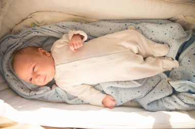 Bebek arabasında yatan küçük şirin bir bebek.