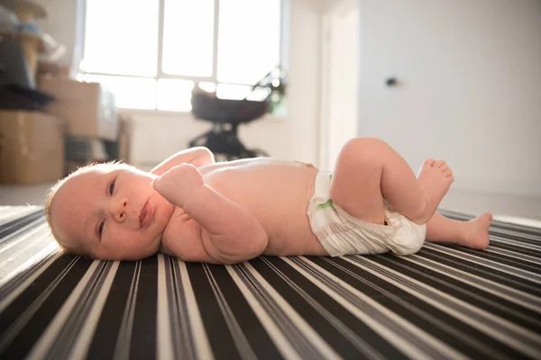 ベッドの上に寝そべっているオムツの新生児 — ストック写真