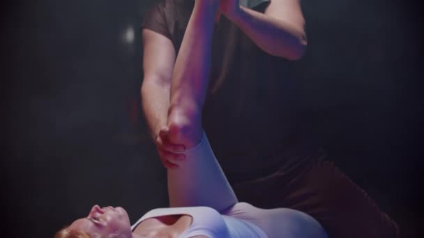 Sessie met een chiropractor - jonge vrouw liggend op haar rug en de therapeut buigt haar been en bewegen naar haar lichaam — Stockvideo