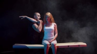 Kayropraktik terapisi. Kadın müşterisi koltukta otururken omuzlarıyla çalışan bir adam.