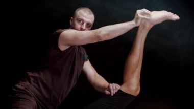 Stüdyoda kiropraktik seansı. Müvekkilinin bacaklarıyla çalışan bir terapist. Bacaklarını vücuduna doğru bastırıyor.