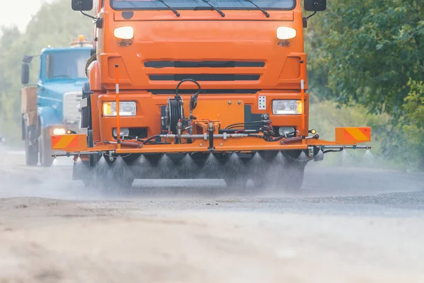 Gran máquina naranja limpia el asfalto con corrientes de agua — Foto de Stock