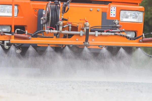 Gran máquina naranja limpia el asfalto con corrientes de agua dirigidas — Foto de Stock