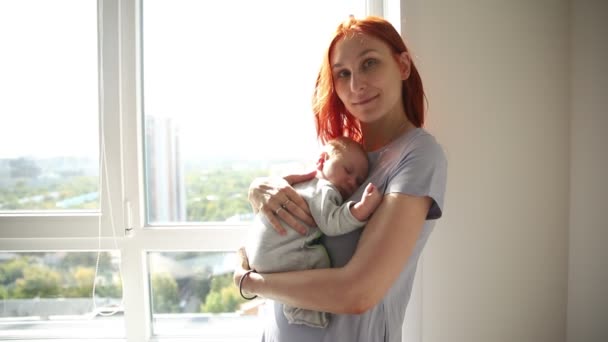 Ingefära kvinna mor håller sitt barn — Stockvideo
