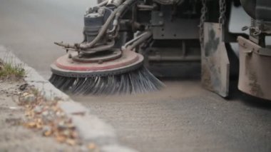 Makine büyük bir süpürge ile asfaltı temizler