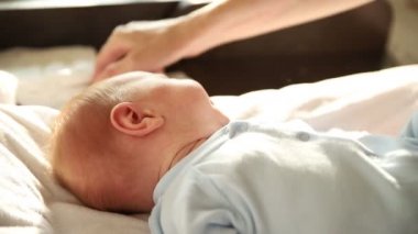 Yeni doğmuş küçük bebeğin yüzünü siliyorum.