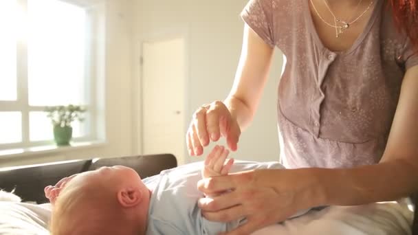 Мама масажує маленькі пальці новонародженої дитини вправи для немовлят — стокове відео