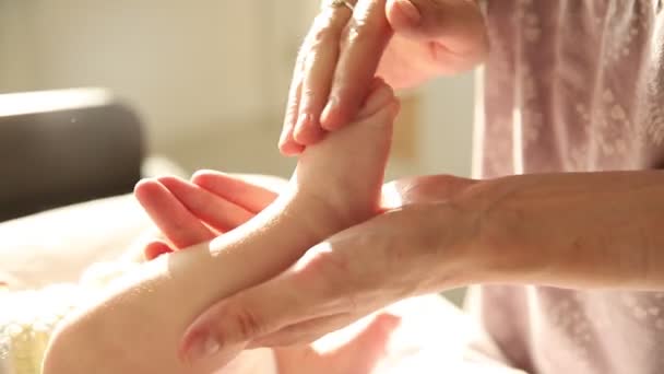 Mama robi ćwiczenia dla swojego nowonarodzonego dziecka - zginając jego małą stopę — Wideo stockowe