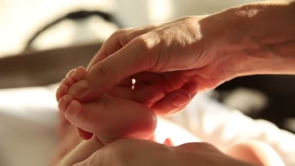 Oefeningen voor baby 's - moeder masseert de voet van haar baby - drukt op de plekken — Stockvideo