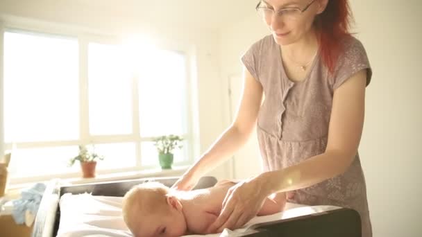 Ασκήσεις για μωρά - μωρό ξαπλωμένο στο στομάχι του και η κοκκινομάλλα μητέρα του να τον χαϊδεύει στην πλάτη — Αρχείο Βίντεο
