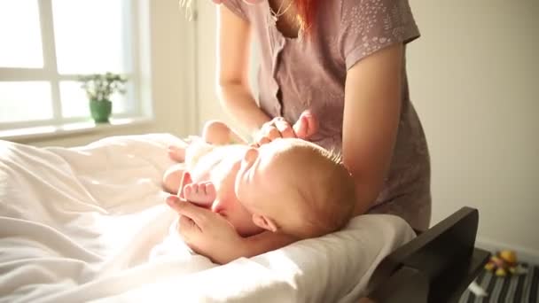Το μωρό ξαπλωμένο στο στομάχι του και η μητέρα του έτοιμη να αλλάξει πάνα. — Αρχείο Βίντεο