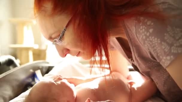 Älskade mor leker med sitt lilla nyfödda barn - gnider näsan med näsan — Stockvideo