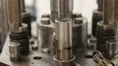 Bir fabrikada bir araba diski yapmak - bir basılı makine diskte delikler açıyor - yukarı ve aşağı gidiyor