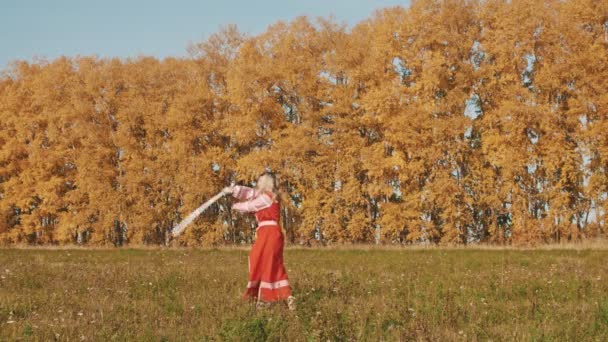 Loira mulher feroz em vermelho longo vestido nacional esgrima com duas espadas — Vídeo de Stock
