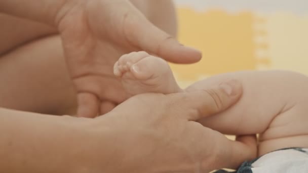 Mère faisant des exercices avec le pied de son bébé — Video