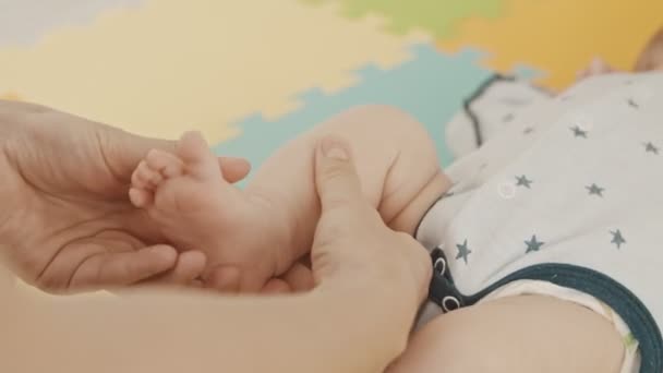 Mère faisant des exercices doux avec le petit pied de son bébé - pliant le pied de haut en bas — Video