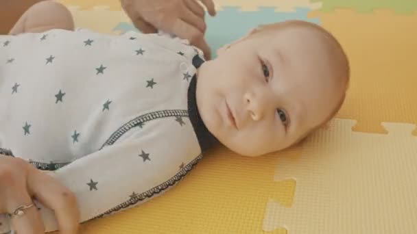 Petit bébé allongé sur le dos pendant que sa mère le tapote — Video