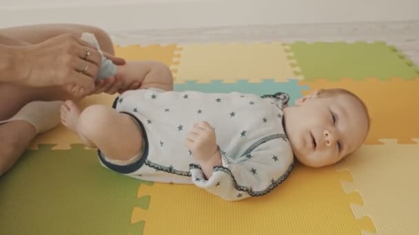妈妈把袜子放在婴儿的脚上 — 图库视频影像