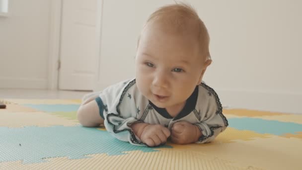 Petit garçon couché sur le ventre sur le tapis — Video