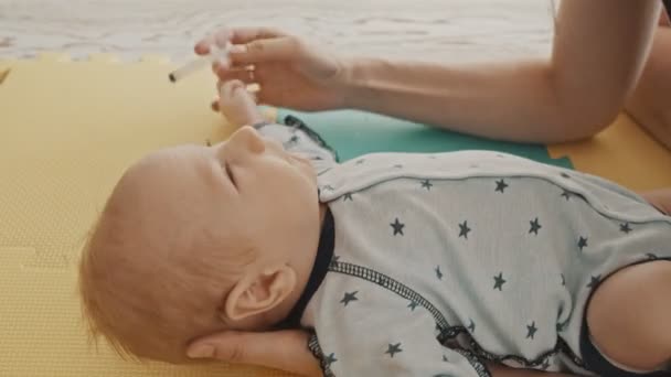 Мать со своим ребенком - промывает ему нос изнутри шприцем — стоковое видео