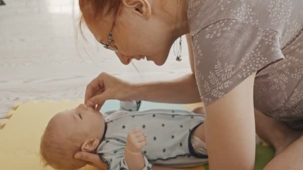 Matka z dzieckiem - czyści mu nos bawełną od środka — Wideo stockowe
