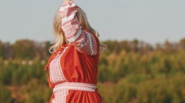 Kırmızı elbiseli alıngan yetişkin kadın iki kılıçlı ve şarkı söyleyen