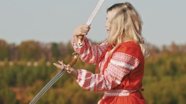 Divoká dospělá žena v červených šatech bojuje se dvěma meči — Stock video