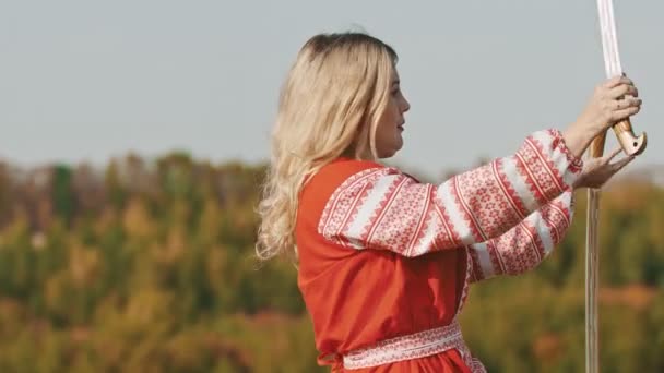 Feisty erwachsene Frau in rotem Nationalkleid kämpft mit zwei Schwertern — Stockvideo