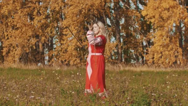 Concepto medieval mujer en rojo vestido largo nacional con maestría empuña dos espadas — Vídeos de Stock