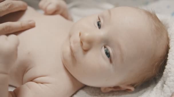 Un petit bébé mignon aux yeux bleus couché au lit avant de dormir — Video