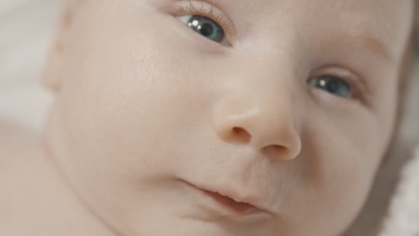 Cara de un pequeño bebé riendo con ojos azules — Vídeos de Stock