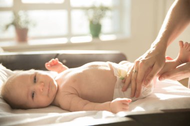 Anne küçük bebeğinin bacaklarına masaj yapıyor.