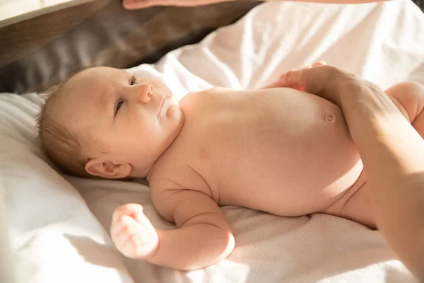 Ett litet barn som ligger på en säng — Stockfoto