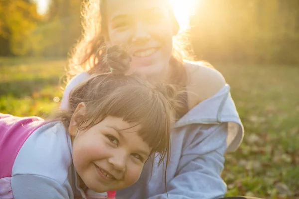 Due sorridenti sorelle che trascorrono del tempo nel parco autunnale — Foto Stock