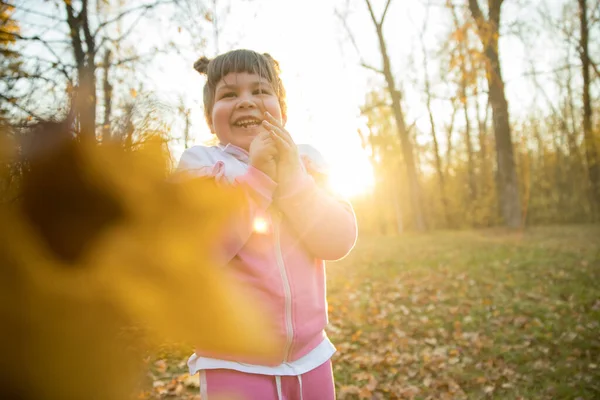 Una niña pequeña de pie en el parque de otoño — Foto de Stock