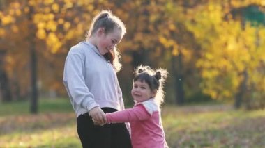 İki kız kardeş sonbahar parkında vakit geçiriyorlar.